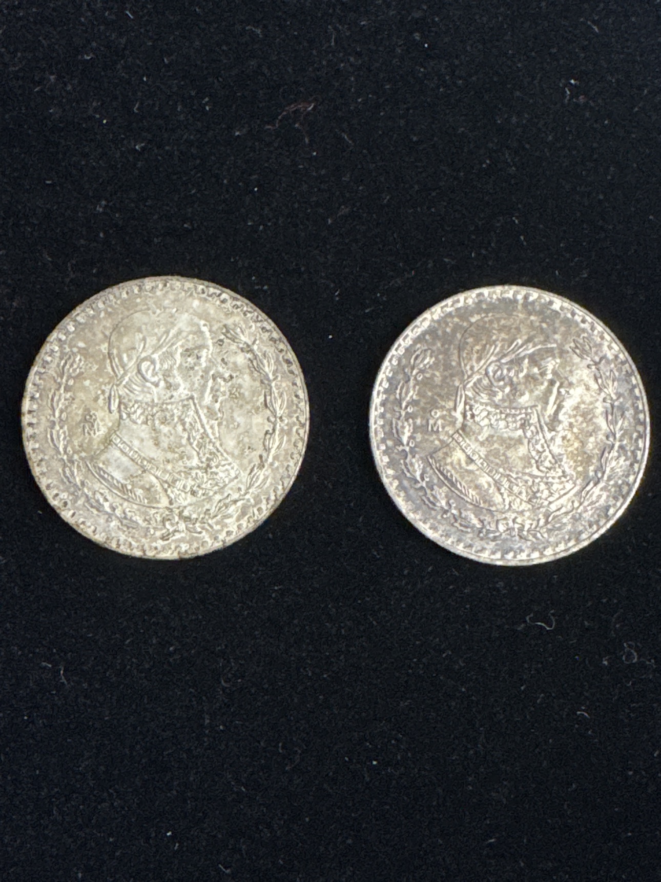 Portrait side of two circulated Mexican one peso silver coins dated 1962 and 1965
